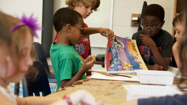 boy in red crew neck t-shirt sitting beside boy in blue crew neck t-shirt